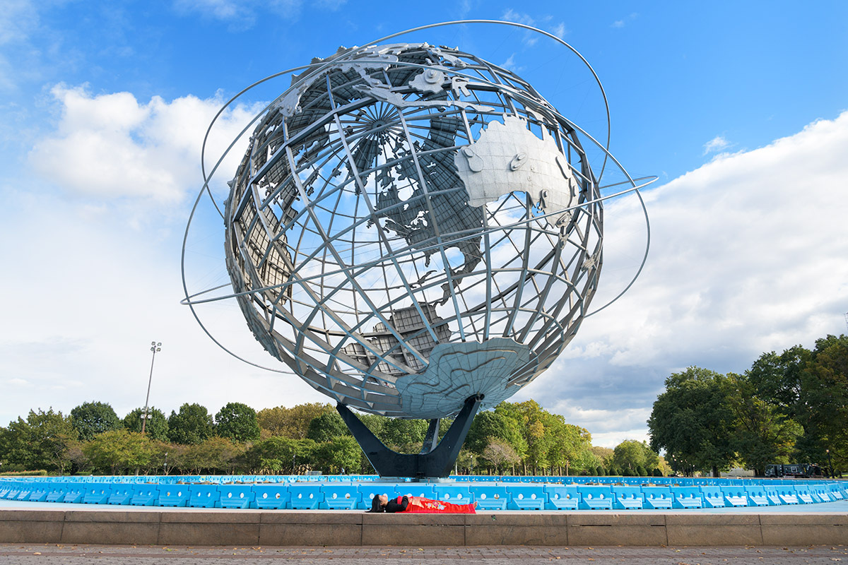 Chun Hua Catherine Dongs sleeps in front of Unisphere in New York City