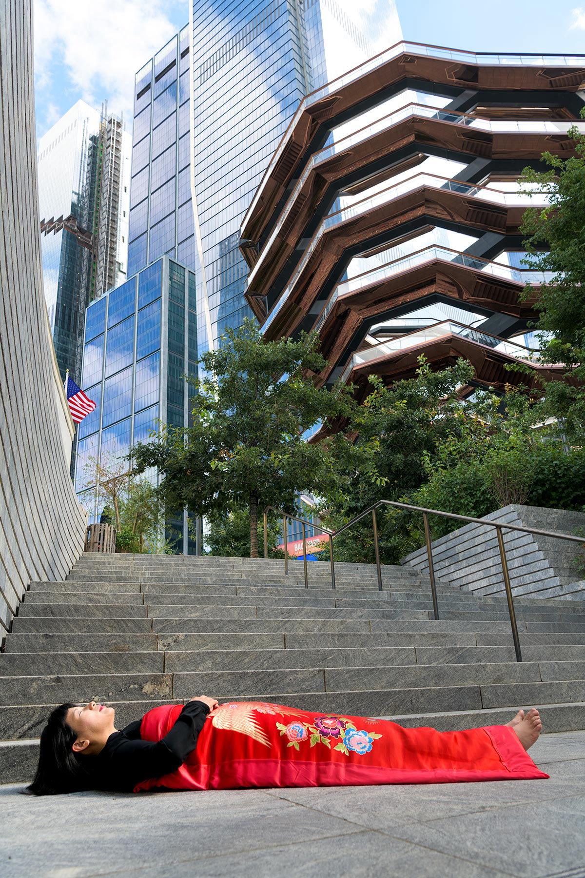 Chun Hua Catherine Dong sleeps in front of the Vessel in New York City