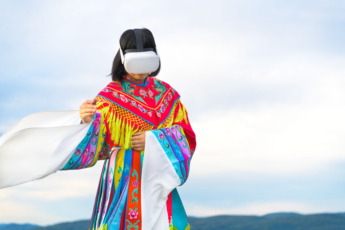 Chun Hua Catherine Dong wears Oculus VR headset and a red Chinese opera costume beside the St. Lawrence River.