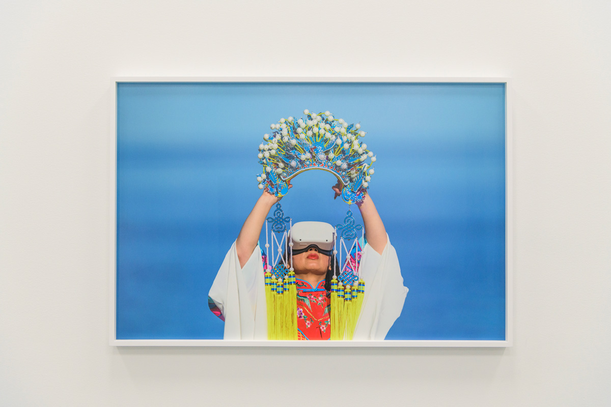 A woman wearing a VR headset holding a crown above her head at Fondation PHI Montreal