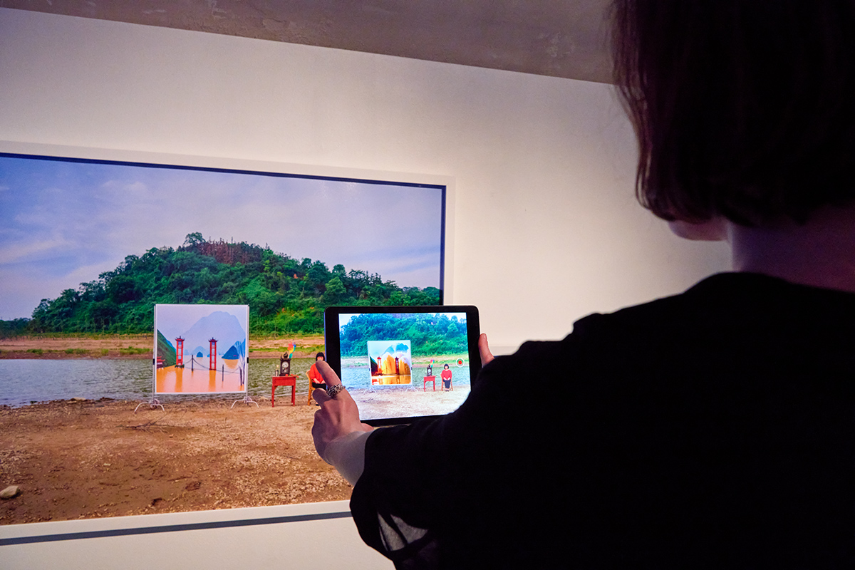a girl activate Chun Hua Catherine Dong's augmented reality on a photograph at Galerie Charlot in Paris