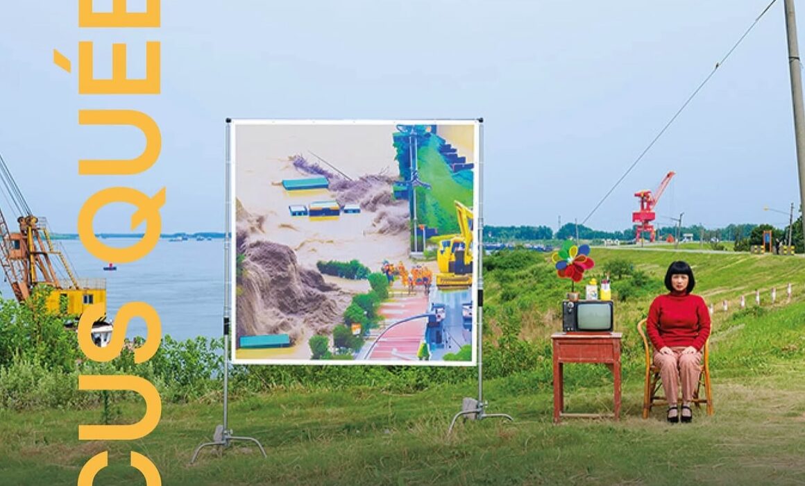 A girl wearing red sits beside a large board